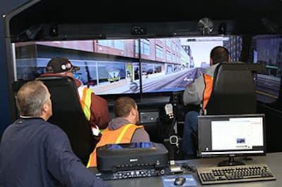 several people sitting in front of virtual driving machine