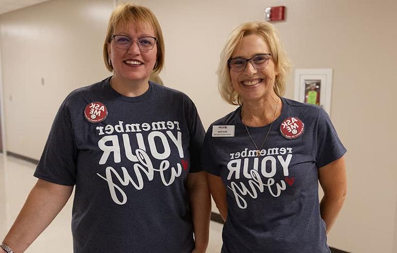 fvtc employees standing in hallway wearing remember your why shirts