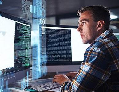 man working on software development coding using two monitors