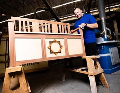 person working on building a bench in woodworking shop