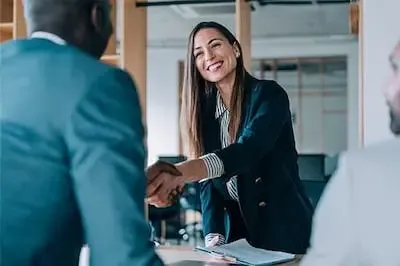 two business people shaking hands across a table